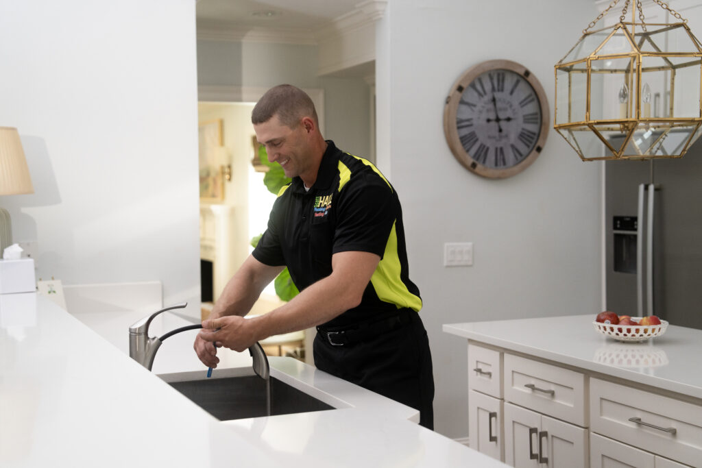plumber working on faucet plumbing