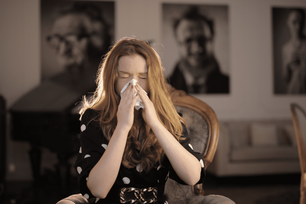 Woman blowing nose into tissue from poor indoor air quality