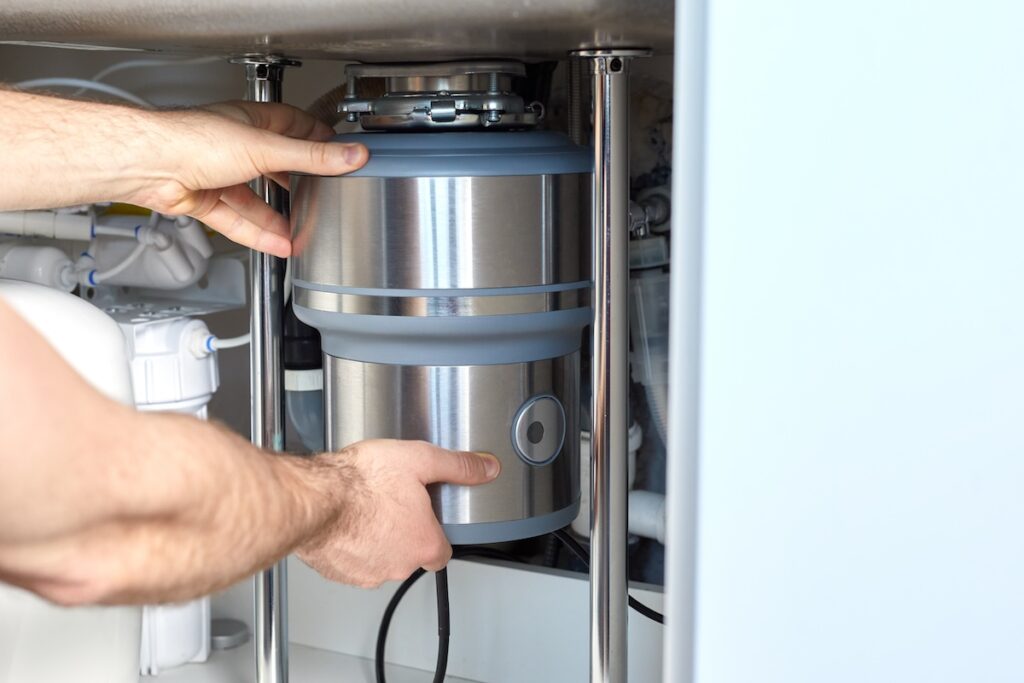 plumber working on kitchen garbage disposal