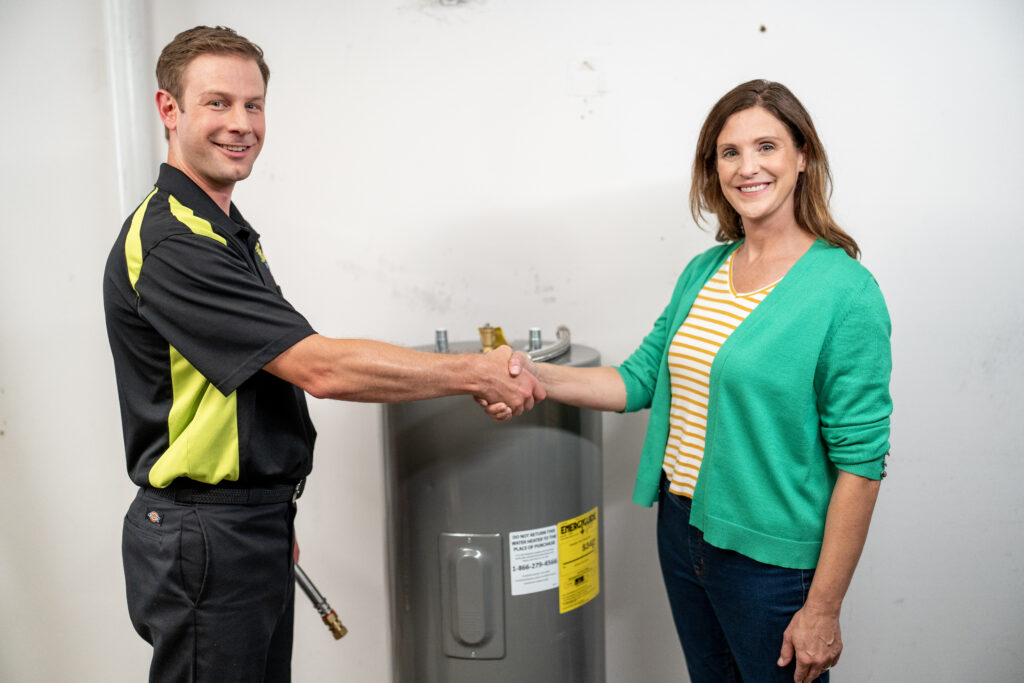 Scott Hale Plumber & customer shaking hands over water heater