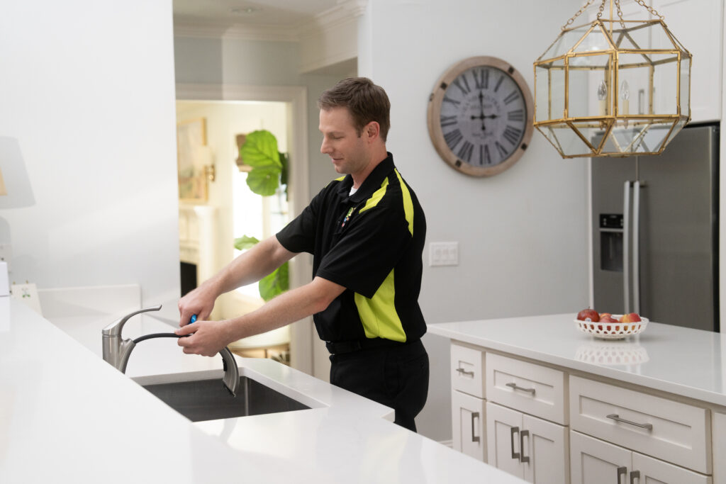 plumber installing new kitchen faucet
